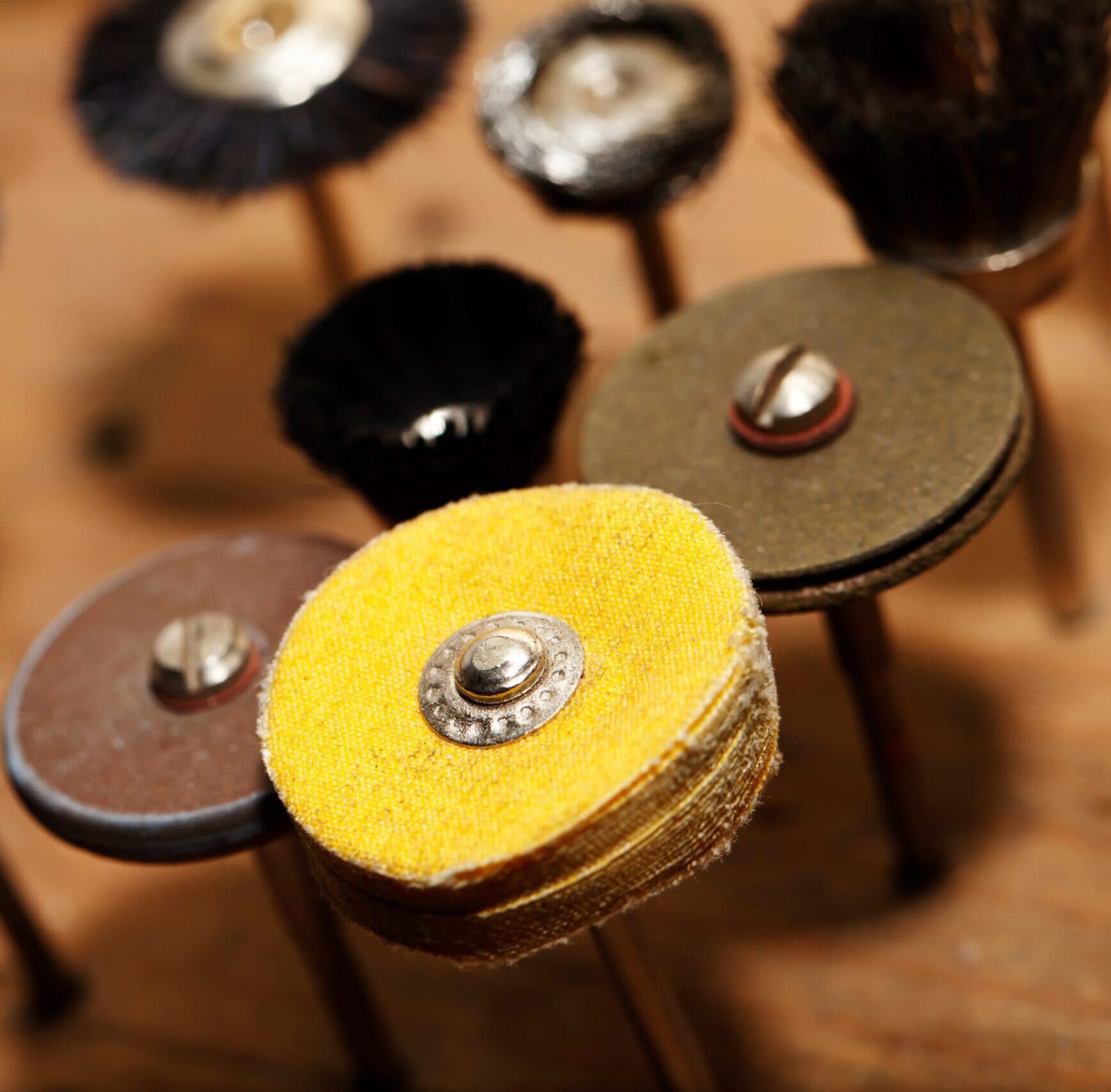 Assorted jeweler polishing wheels and sanding discs on wooden mandrels