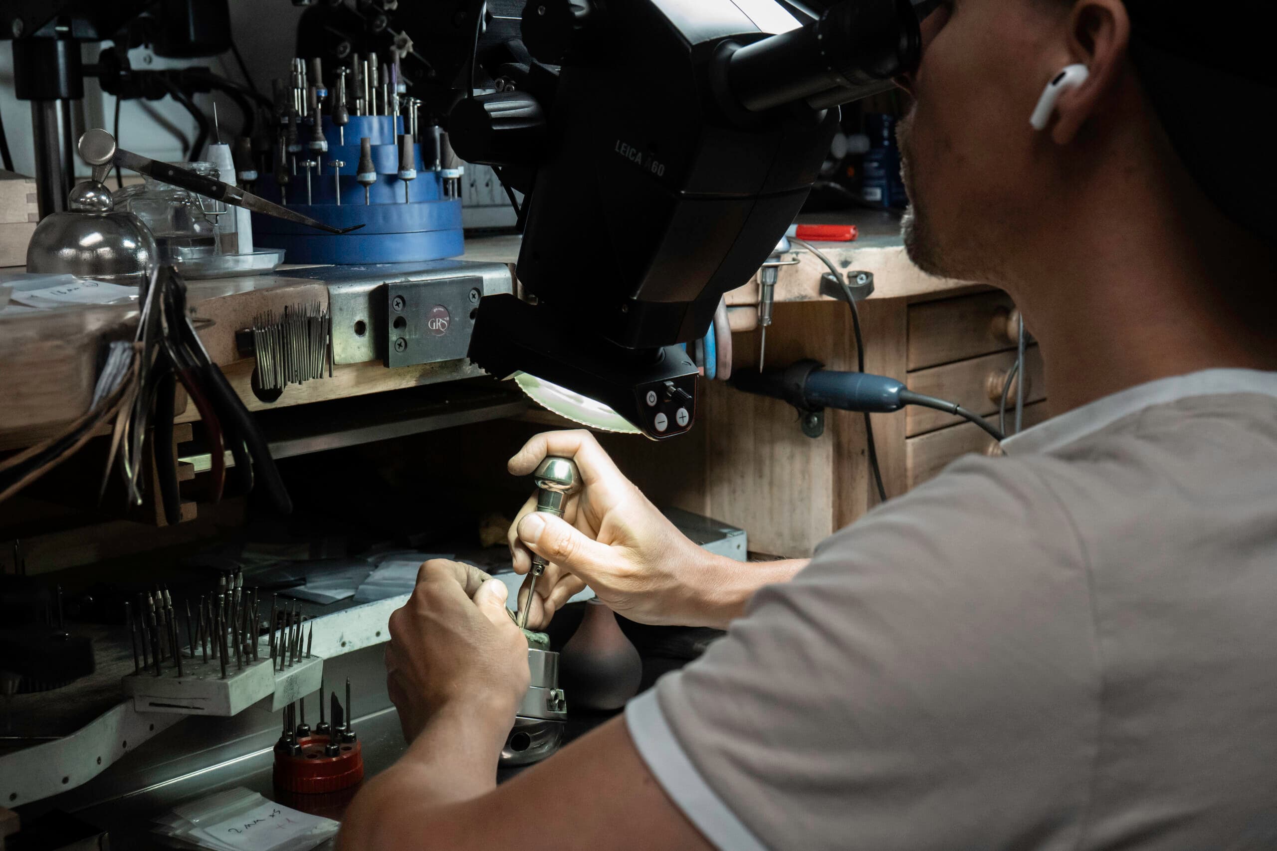 Jeweller working under a Leica microscope at a GRS engraving bench with precision tools